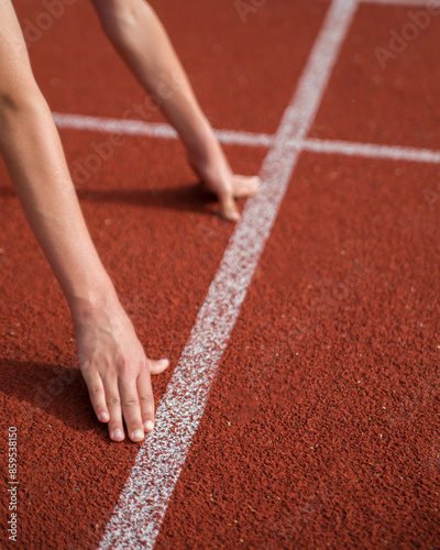 An athlete stands on the starting line at the stadium.