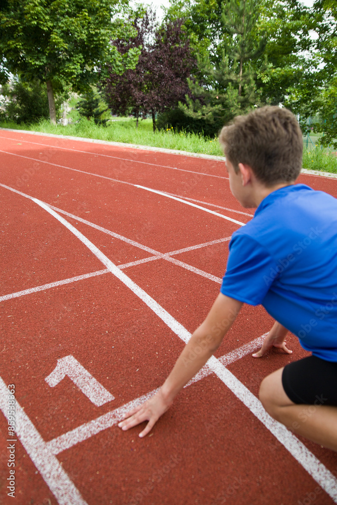 An athlete stands on the starting line at the stadium. An athlete stands on the starting line at the stadium.