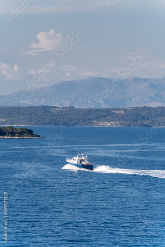 View of boat in Adriatic sea and Dinaric alps mountains in background.  View from Hvar back to Split, Croatia