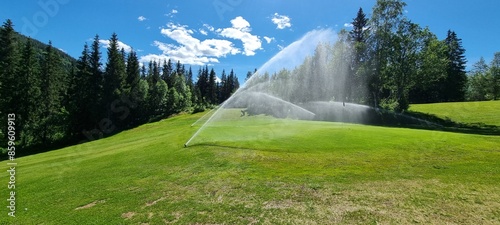 sprinklers on golf greene in summmer with clear blue sky and warming sunshine in mosjøen nordland