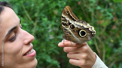 young Latina holding an Owl Butterfly (Caligo memnon) at the butterfly garden in Mindo, Ecuador