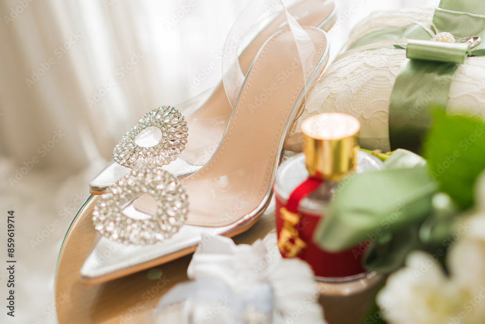 Elegant bridal shoes in wedding preparation. surrounded by bridal accessories, champagne bottle, perfume, garter, rings, bouquet of roses and pillow. Elegant bridal shoes in wedding preparation. surrounded by bridal accessories, champagne bottle, perfume, garter, rings, bouquet of roses and pillow.