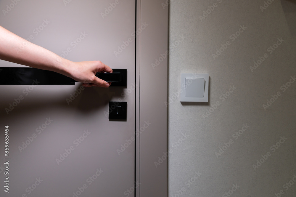 A woman's hand opens the door to the room. Copy space A woman's hand opens the door to the room. Copy space