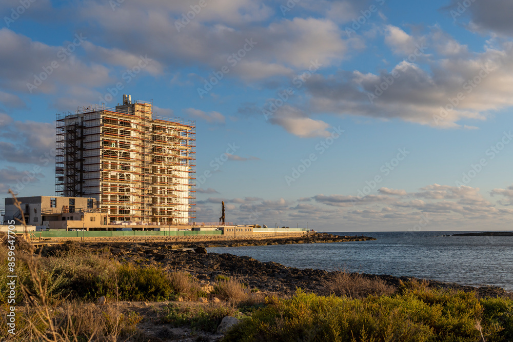 Obraz premium General view of a hotel under restoration in the Mallorcan tourist resort of Colonia de Sant Jordi at sunset. Balearic Islands