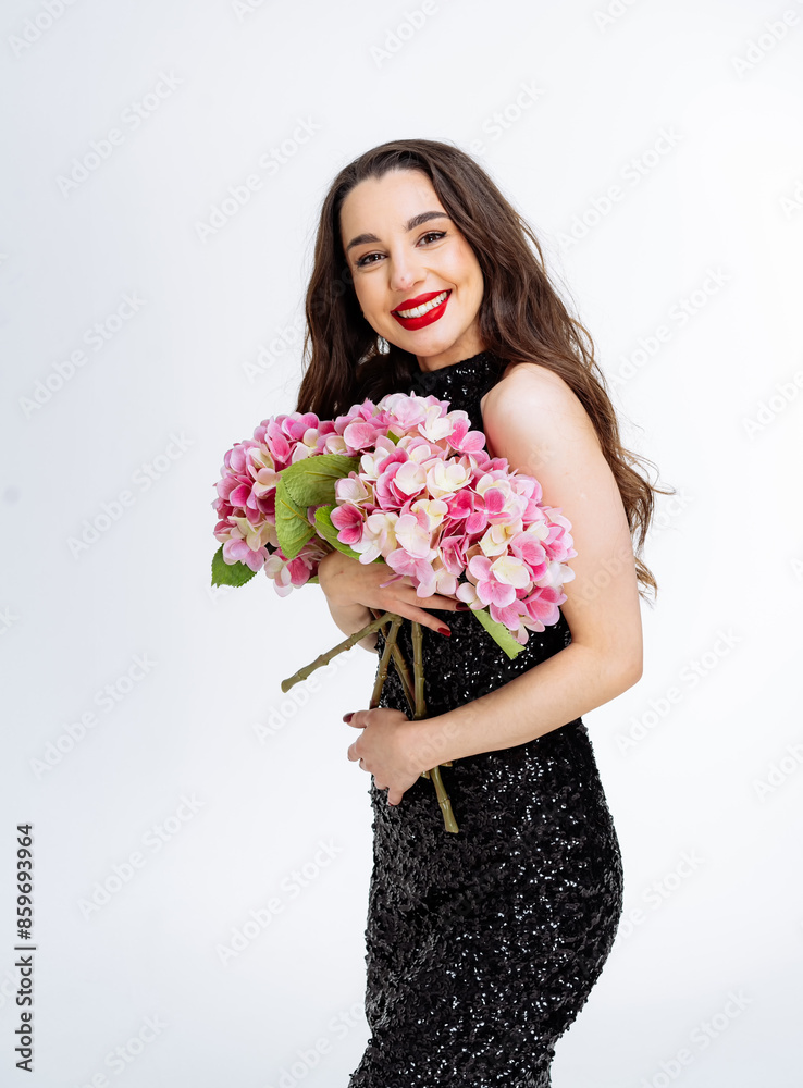 Woman Holding Pink Flowers in Black Dress. A woman in a black sequined dress smiles and holds a bouquet of pink hydrangeas. Woman Holding Pink Flowers in Black Dress. A woman in a black sequined dress smiles and holds a bouquet of pink hydrangeas.