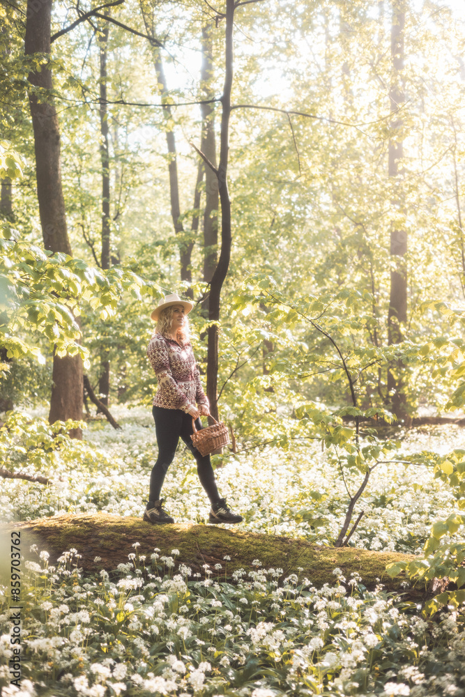 Blonde woman in a flannel sweatshirt and hat holding a wicker wooden basket. Walk for fresh bear garlic for future troubles. Gathering, trekking and fresh air Blonde woman in a flannel sweatshirt and hat holding a wicker wooden basket. Walk for fresh bear garlic for future troubles. Gathering, trekking and fresh air