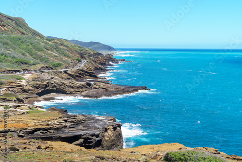 The scene shows a cliff with a view of a body of water under the clear sky