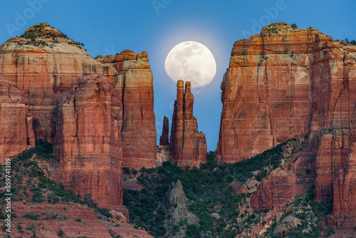 Fototapeta Naklejka Na Ścianę i Meble -  A waxing gibbous moon rises up over a sandstone spire in Sedona Arizona