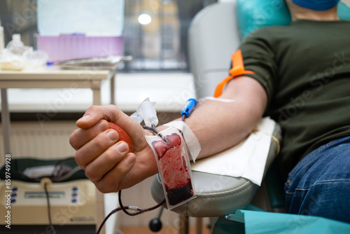 man donor for bone marrow donation blood in laboratory. male hand holding red ball, prevention of diseases, illness hemodialysis transfusion in hospital. soft focus