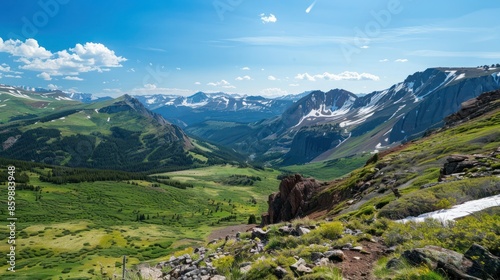 Summer Adventure: A rugged mountain landscape with snow-capped peaks, lush green valleys, and a clear blue sky. Room for text overlay on the mountains or in the sky. 