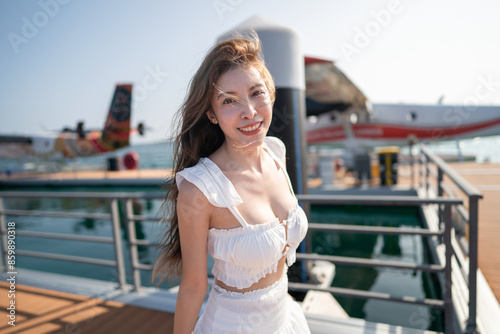 Woman with a seaplane background before boarding. © marchsirawit