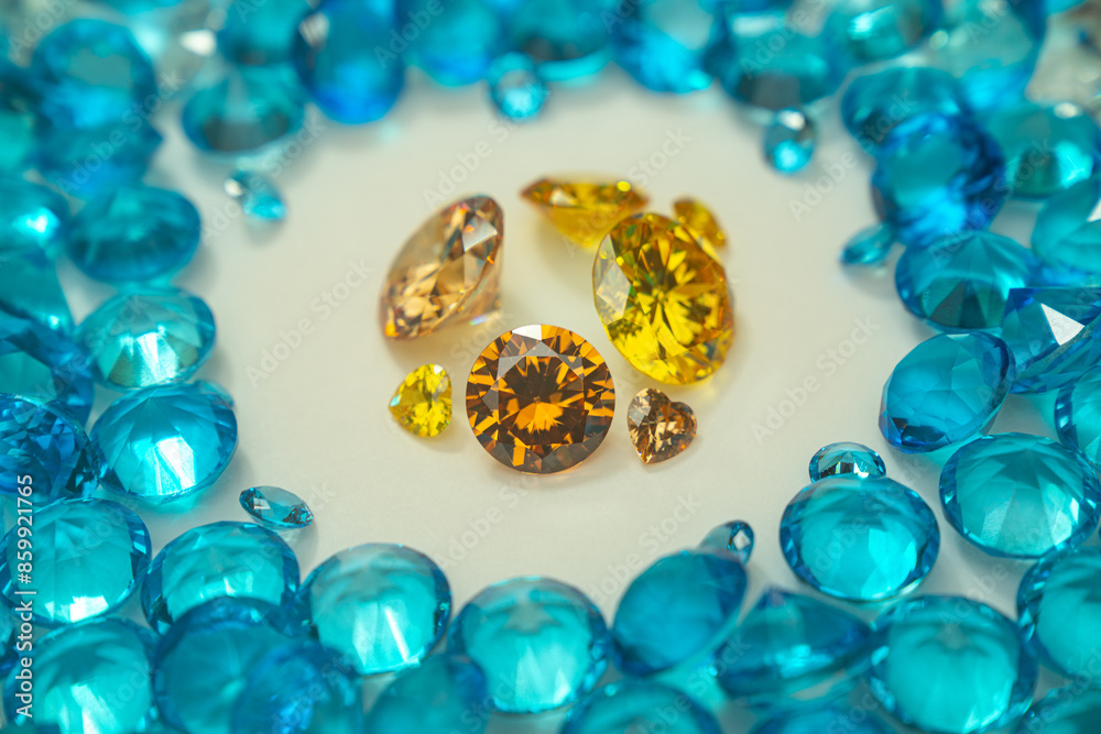A group of Yellow diamonds arranged in the middle of blue diamonds in a white background.Diamonds are highly valued as expensive pieces of jewelry..The sparkling light of the diamonds is beautiful.. A group of Yellow diamonds arranged in the middle of blue diamonds in a white background.Diamonds are highly valued as expensive pieces of jewelry..The sparkling light of the diamonds is beautiful..