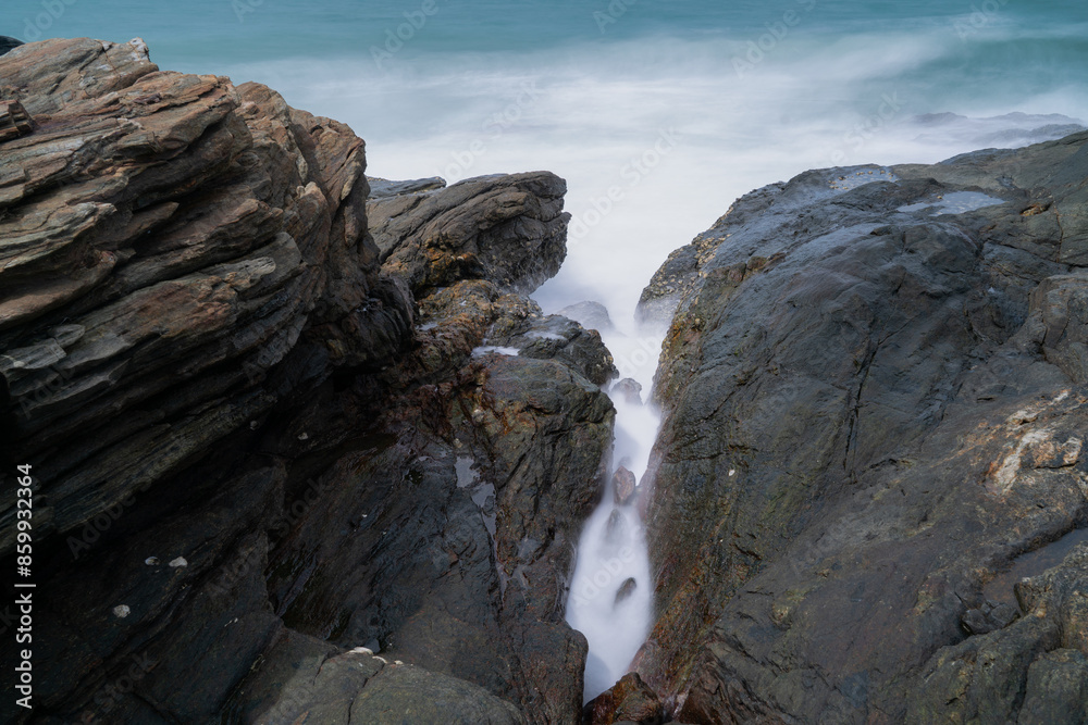 The waves crash against the rocks on the shore The waves crash against the rocks on the shore