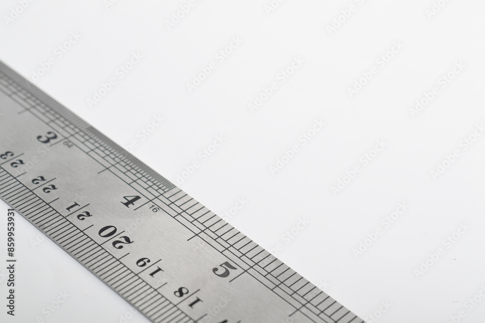 Iron ruler on a white background. Stainless steel ruler. Stationery and work tools made of metal steel. Selective focus, isolated on white background Iron ruler on a white background. Stainless steel ruler. Stationery and work tools made of metal steel. Selective focus, isolated on white background