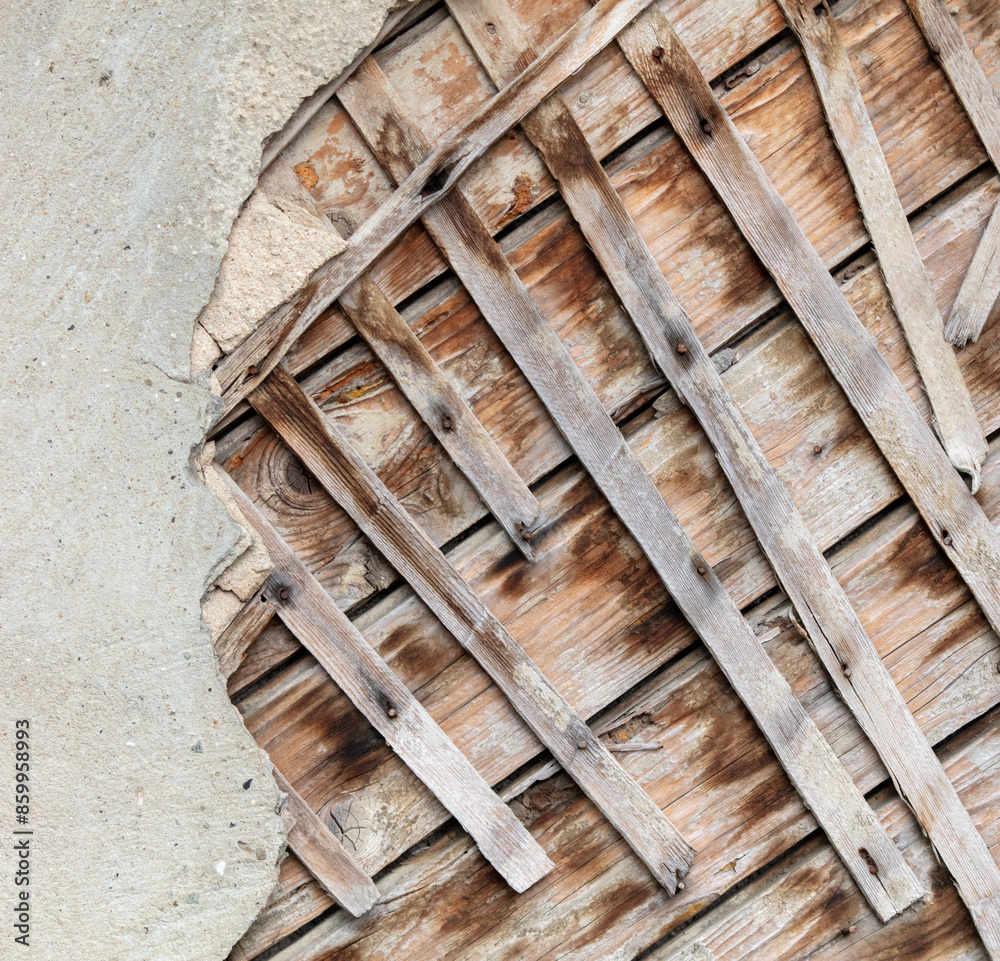 Old wood under the plaster of a cracked wall. Abstract background