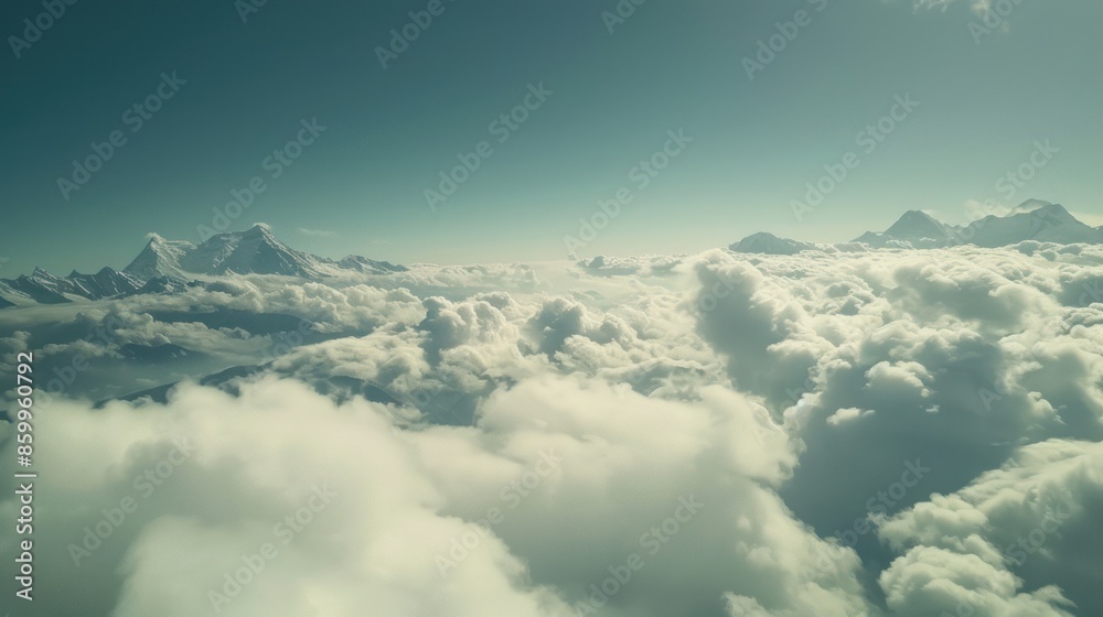 Fototapeta premium Aerial View of Snow-Capped Mountains Above the Clouds