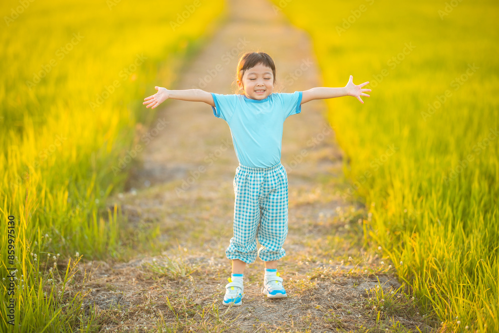baby girl with happy time on freedom in emotional in outdoor by run play on grasses floor in rice fields blue dress baby girl with happy time on freedom in emotional in outdoor by run play on grasses floor in rice fields blue dress