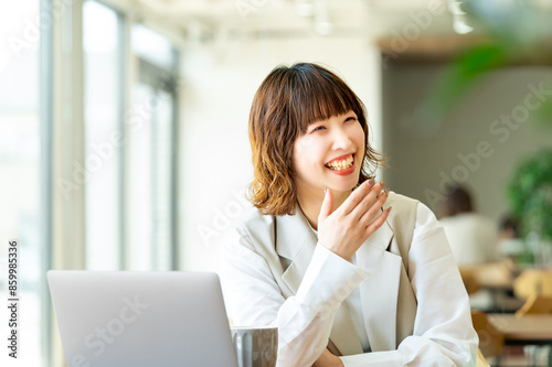 笑顔で話す若い日本人ビジネスウーマン photo