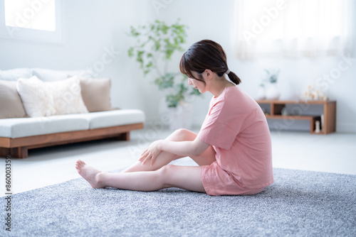 部屋で足のケアをする若い日本人女性 photo