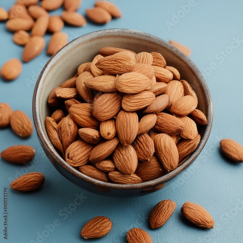 Fresh almonds nut in bowl on blue background  photo