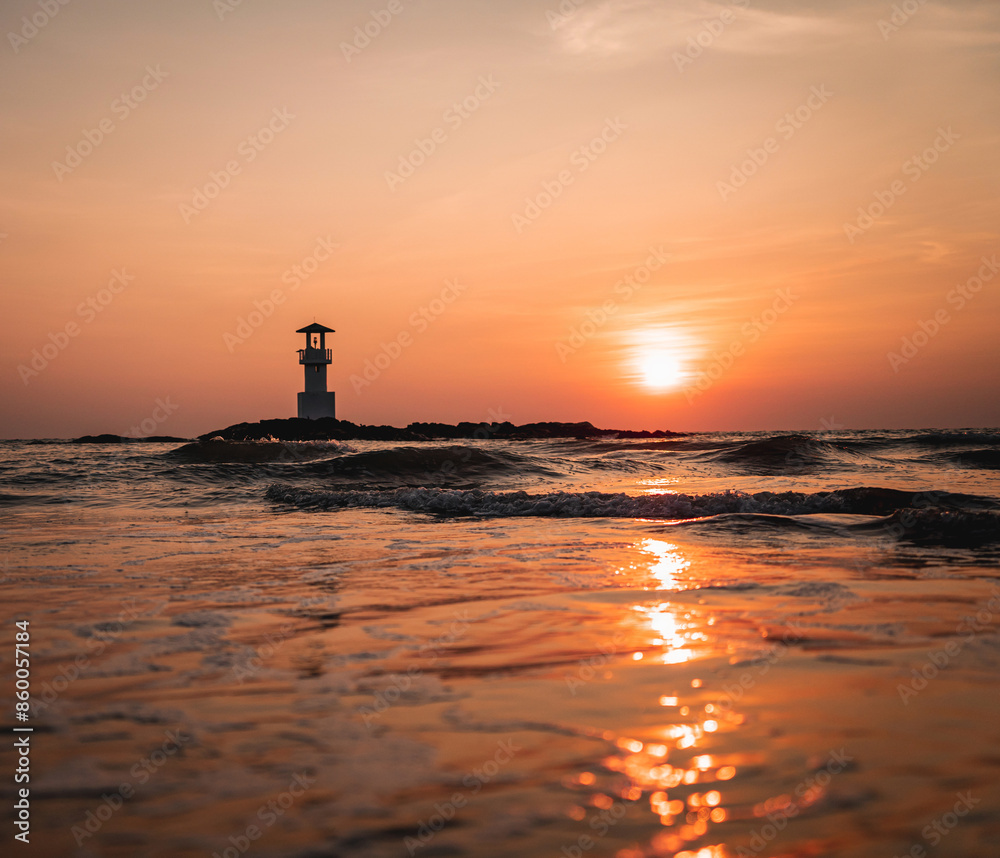 Fototapeta premium A lighthouse in the ocean during a beautiful sunset