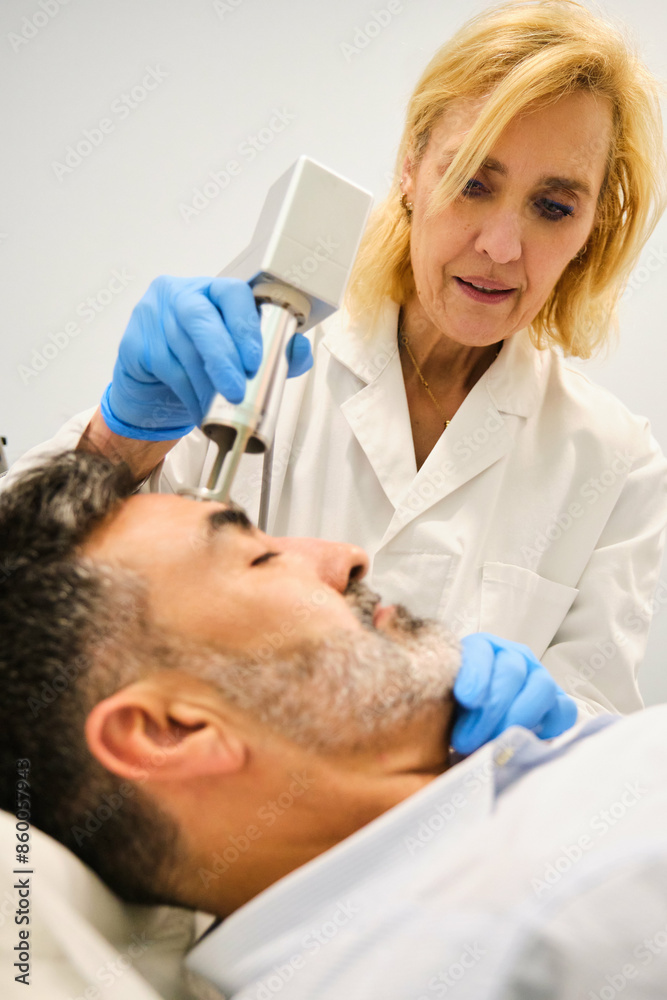 A man is getting a laser skin resurfacing treatment by a aesthetic doctor in a clinic. A man is getting a laser skin resurfacing treatment by a aesthetic doctor in a clinic.