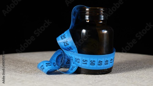 close-up blue measuring tape inside medicine bottle rotates on the turntable. 4k video capture