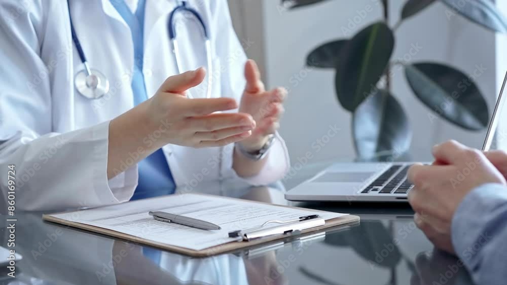 Doctor consulting patient in clinic office while both are sitting at the glass desk. Medicine concept Doctor consulting patient in clinic office while both are sitting at the glass desk. Medicine concept