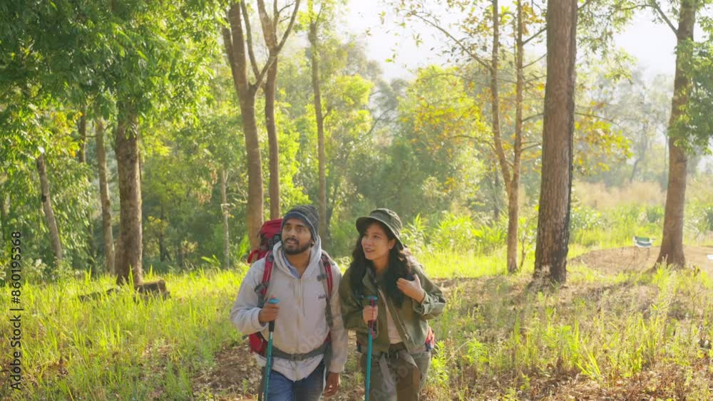 Asian couple backpacker hiking in tropical forest on summer holiday vacation. Man and woman traveler enjoy adventure outdoor active lifestyle walking together on mountain dirt road. Ecotourism concept Asian couple backpacker hiking in tropical forest on summer holiday vacation. Man and woman traveler enjoy adventure outdoor active lifestyle walking together on mountain dirt road. Ecotourism concept