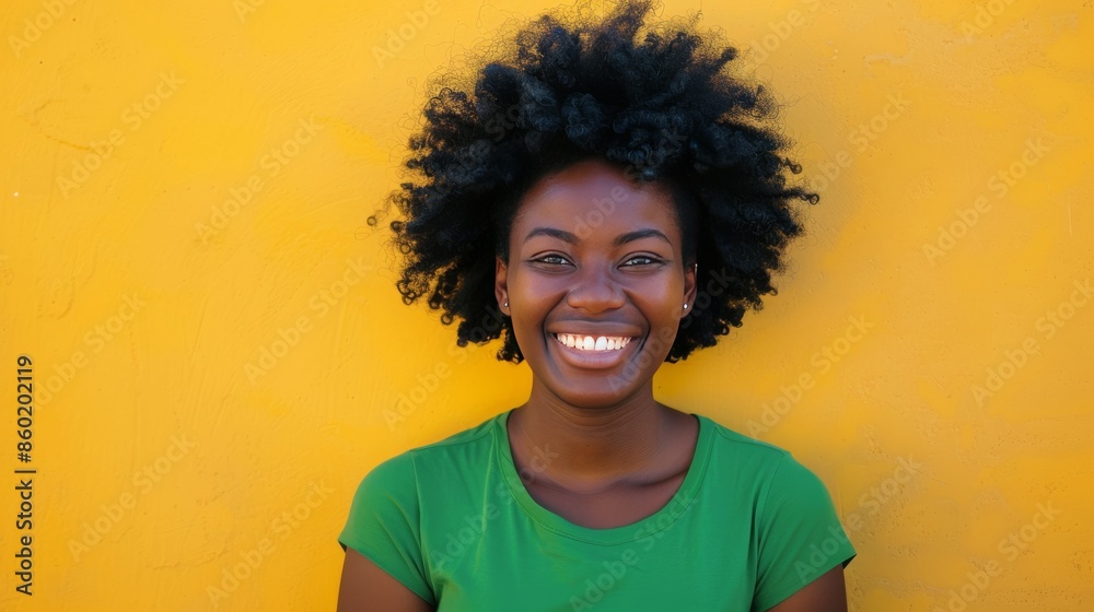 Create an image of a smiling African person. They are wearing a solid color t-shirt and standing in front of a solid color background Create an image of a smiling African person. They are wearing a solid color t-shirt and standing in front of a solid color background