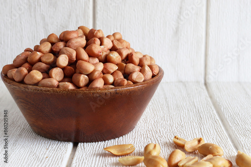peanuts in a wood bowl on background