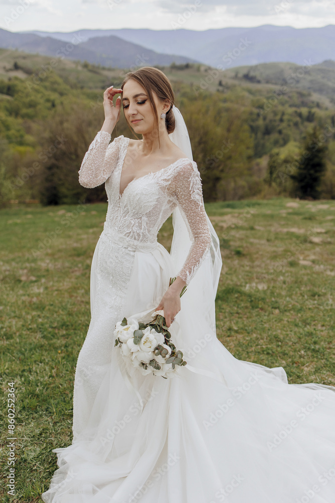A woman in a white wedding dress is standing in a field with a bouquet of flowers in her hand A woman in a white wedding dress is standing in a field with a bouquet of flowers in her hand