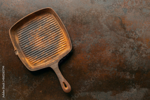 rusty cast iron grill pan on iron rustic background.
