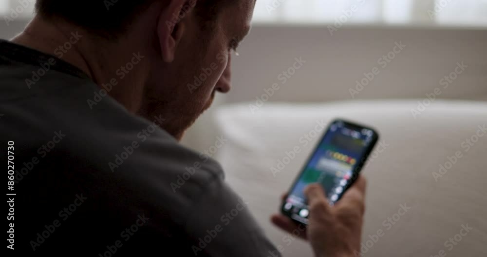 Guy Scrolling on Social Media. guy casually scrolling through social media on his smartphone. contemporary habits. addicted to fake news and scrolling social platforms. wasting time. screen time. 