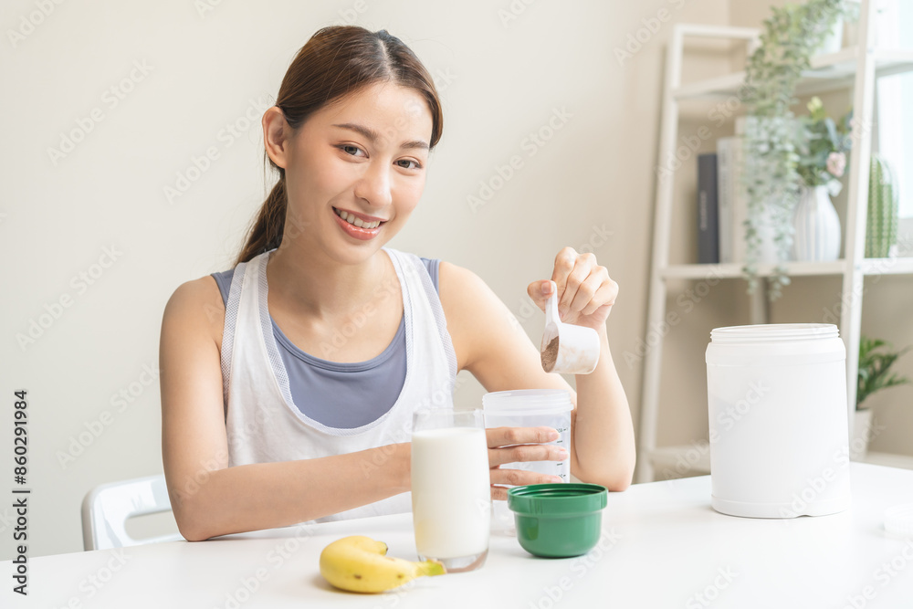 Diet meal replacement for weight loss, smile asian young woman, girl in sportswear, hand in holding scoop making protein shake, drink supplement for muscle after workout at home. Healthy body care. Diet meal replacement for weight loss, smile asian young woman, girl in sportswear, hand in holding scoop making protein shake, drink supplement for muscle after workout at home. Healthy body care.
