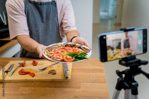 The chef is broadcasting live from workshop how to prepare a grilled eggplants with garlic