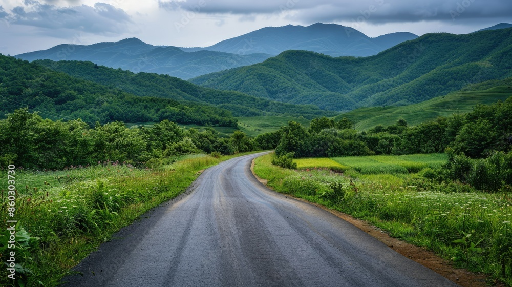 Countryside asphalt road surrounded by green foliage and rolling mountains Countryside asphalt road surrounded by green foliage and rolling mountains