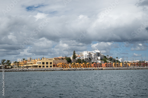 edge of Portimão river Arade flowing out to Atlantic ocean. Apartment complexes overlook Praia da Rocha beach popular tourist destination in Algarve Portugal photo