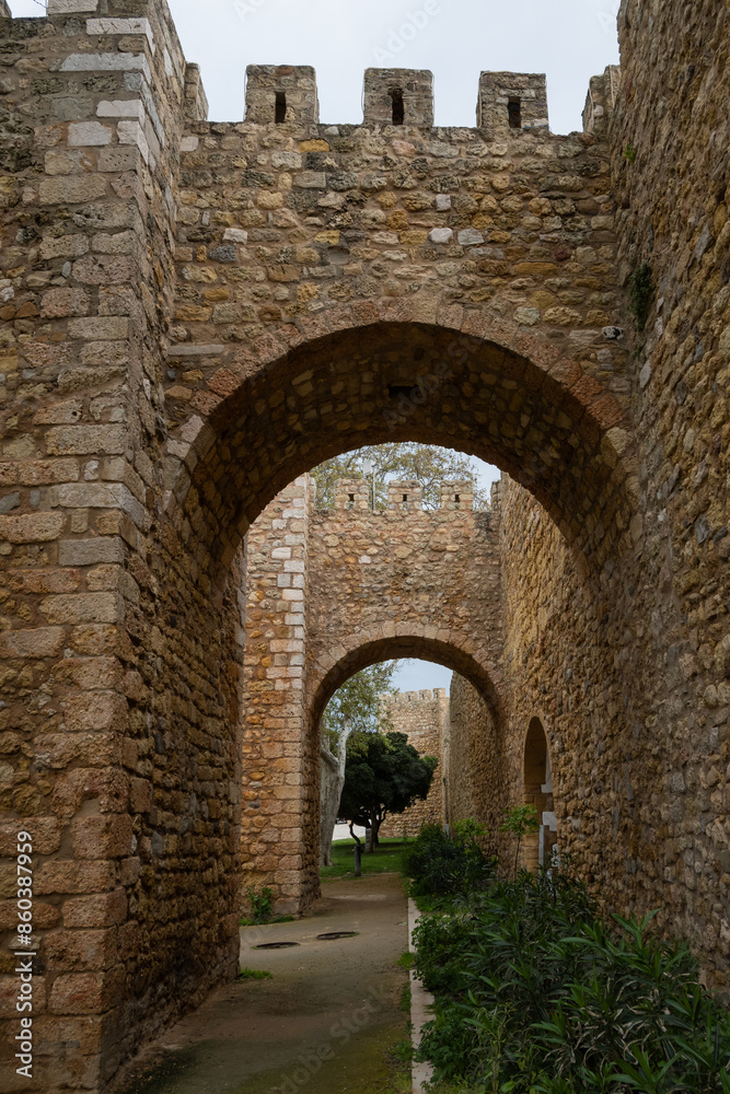 stone gate through Lagos city stone walls Porta de São Gonçalo original historic landmark site protecting barricade that surrounds Algarve town in Portugal with trees next to entrance stone gate through Lagos city stone walls Porta de São Gonçalo original historic landmark site protecting barricade that surrounds Algarve town in Portugal with trees next to entrance
