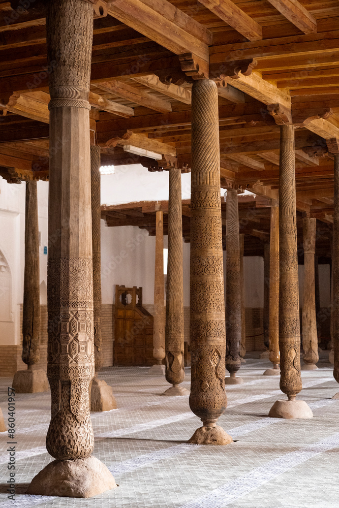 Fototapeta premium Interior of the ancient Juma mosque with wooden carved mosaic columns, in the ancient city of Khiva, Ouzbekistan