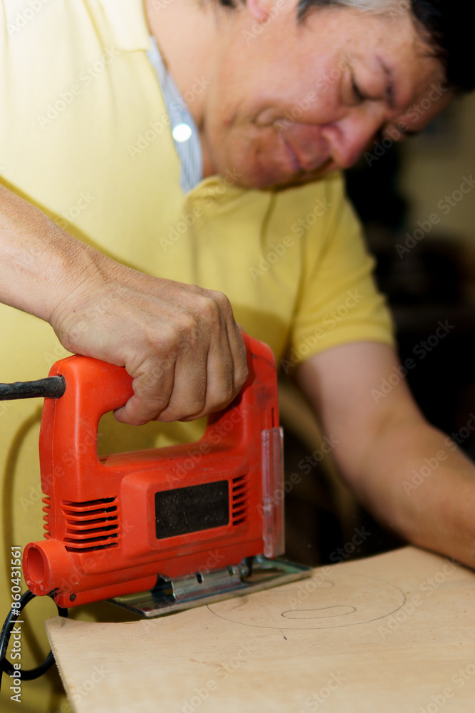 A man is using a power tool to cut a piece of wood A man is using a power tool to cut a piece of wood