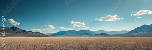 Panoramic View of a Vast Desert with Mountains and Blue Sky