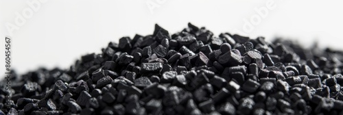 A close-up image of black plastic granules piled high against a white background. The image focuses on the texture and detail of the granules