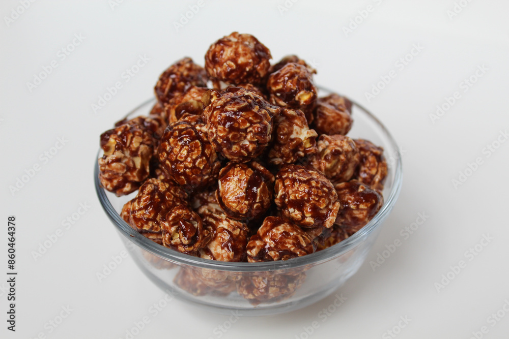 Chocolate popcorn, in transparent glass bowl, isolated on white background