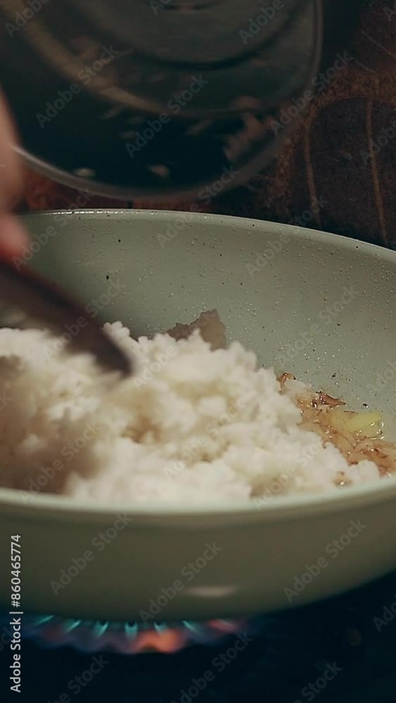 Adding rice to a pan with roasted onions to make filipino fried rice or ...