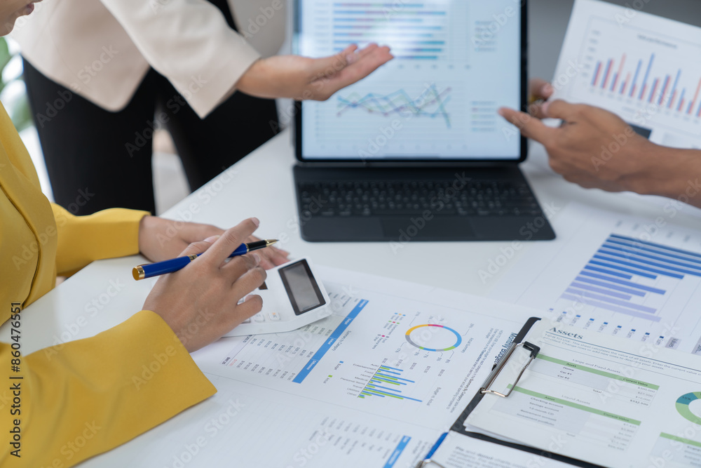 A photograph of a male and female employee's hands as they meet in an office, pens and laptops at the ready as they consult on business matters. A photograph of a male and female employee's hands as they meet in an office, pens and laptops at the ready as they consult on business matters.
