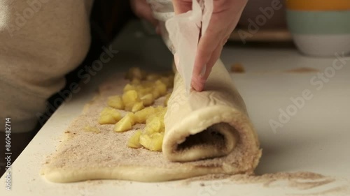 Close up of woman hands wrap cinnamon and sugar in rolled out dough for cinnamon buns. Making cinnamon buns  photo
