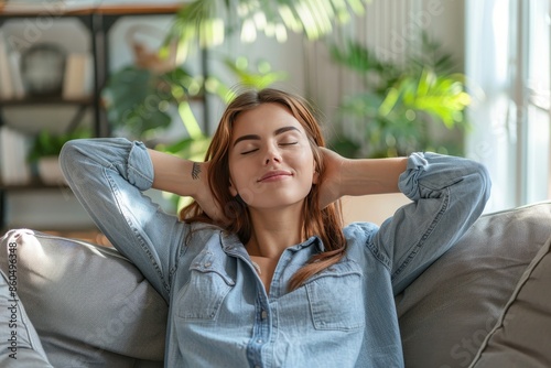 Tranquil young woman relaxing on sofa in modern living room, embracing serenity and wellbeing photo