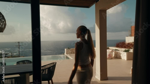 Wallpaper Mural Woman Opens Sliding Door and Steps Out to Oceanfront Terrace Torontodigital.ca