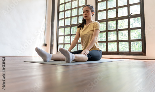 Female girl Attractive young asian woman doing stretching exercise on mat yoga Calmness and relax at gym Full body concentrated flexibility during workout